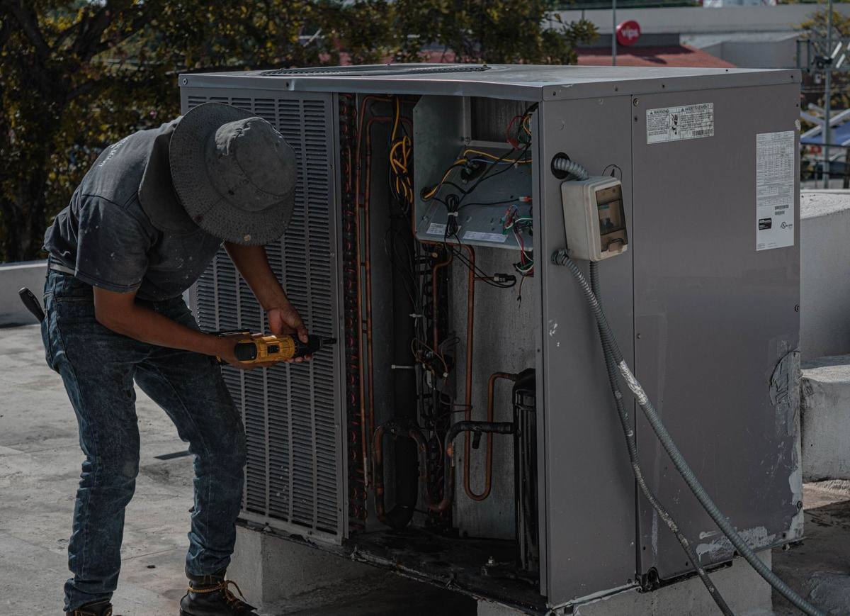 Technician servicing a rooftop HVAC unit